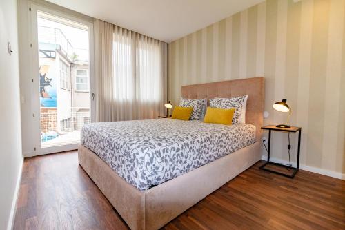 Un dormitorio con una cama y una ventana grande. en Ceuta Inn Porto, en Oporto