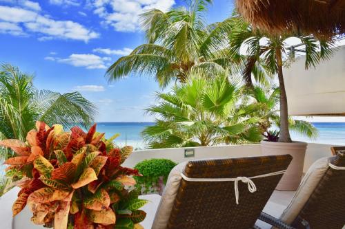 a balcony with a table and chairs and the ocean at Playa Palms Beach Hotel in Playa del Carmen