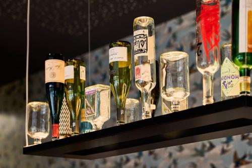 a shelf with wine glasses and wine bottles at Parkhotel Rothof in Munich