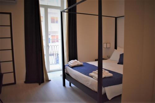 a bedroom with a four poster bed and a window at Gatto Bianco Duchessa in Bari