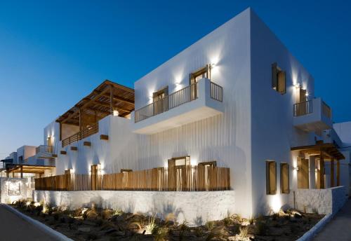 a white building with wooden balconies on it at night at Arco Solium Suites in Adamas