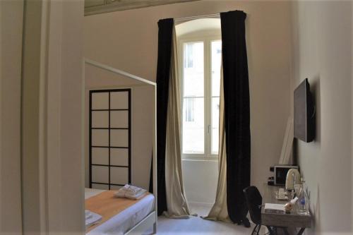 a bedroom with a bed and a mirror and a window at Gatto Bianco Duchessa in Bari