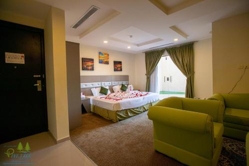 - une chambre avec un lit, un canapé et des chaises dans l'établissement Pinetree Suites Hail, à Haïl