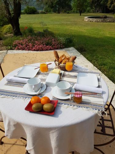 una mesa con un plato de comida y fruta. en Les Néfliers chambre d'hôtes, en Céreste