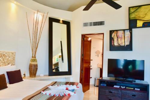 a bedroom with a bed and a tv and a mirror at Playa Palms Beach Hotel in Playa del Carmen