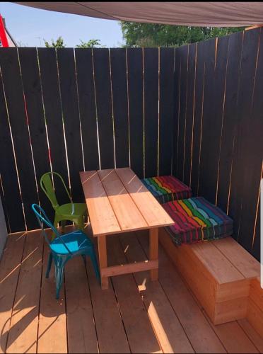 a wooden table and chair on a wooden deck at Maison design perros guirec, 2 à 4 personnes in Perros-Guirec