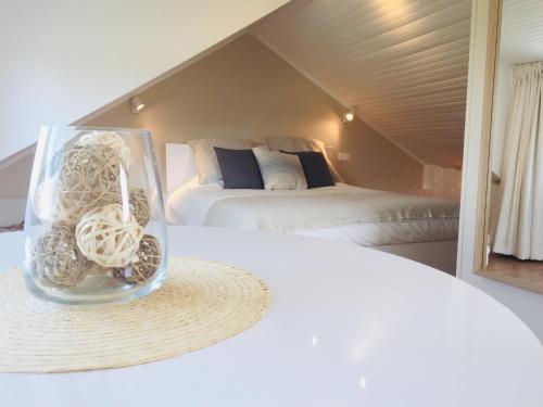 um vaso de vidro cheio de cebolas sentado numa cama em Aux pieds des vaches em Charneux