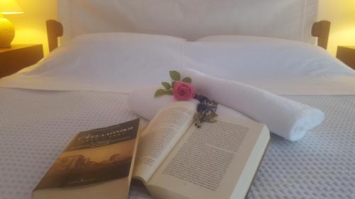 a book laying on a bed with a rose on it at Villa Georgia Poseidi in Kalandra