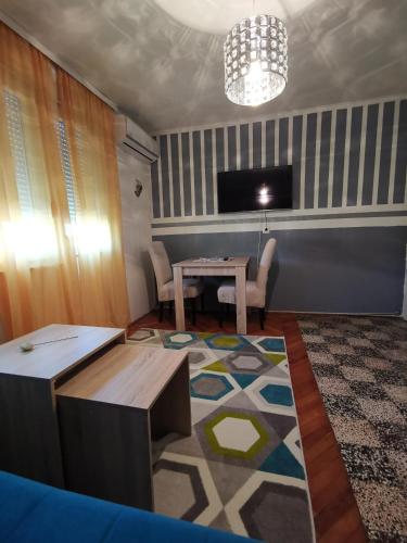 a living room with a table and a tv at Apartment I&M Capljina in Čapljina