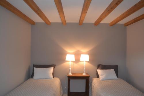 2 camas en una habitación con 2 lámparas en Gîte de Dargilan, en Meyrueis