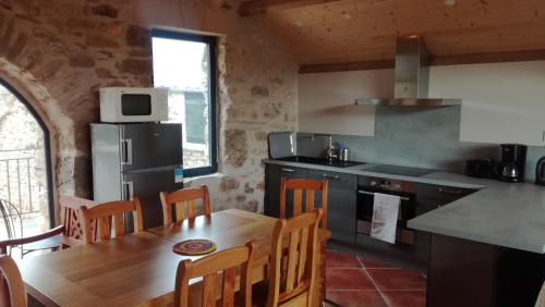 a kitchen with a wooden table and a dining room at Gîte de Dargilan in Meyrueis