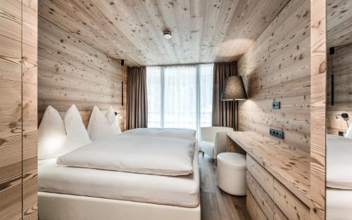 a hotel room with two beds and a window at Chalet Ourtls Pärg in Solda