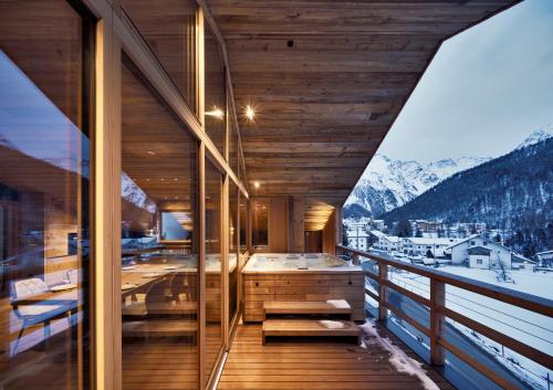 a room with a tub on a balcony with mountains at Chalet Ourtls Pärg in Solda