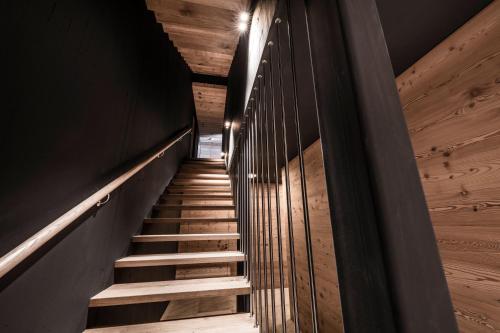 a staircase in a house with wooden walls and wooden floors at Chalet Ourtls Pärg in Solda