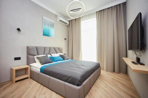 - une chambre avec un grand lit et une télévision dans l'établissement Ванный переулок Апартаменты Миконос, à Odessa
