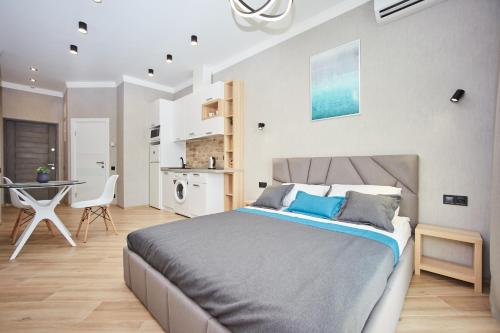 Cet appartement comprend une chambre avec un lit et une table ainsi qu'une cuisine. dans l'établissement Ванный переулок Апартаменты Миконос, à Odessa