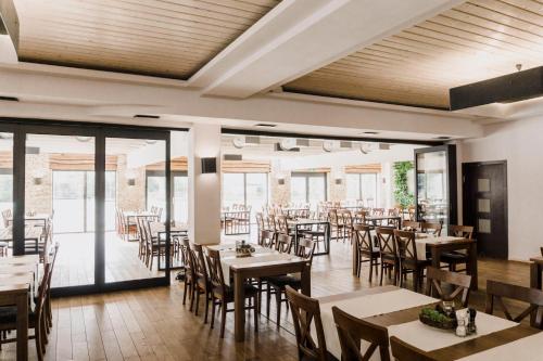 a dining room with tables and chairs and windows at Hotel Borowina in Konstancin-Jeziorna