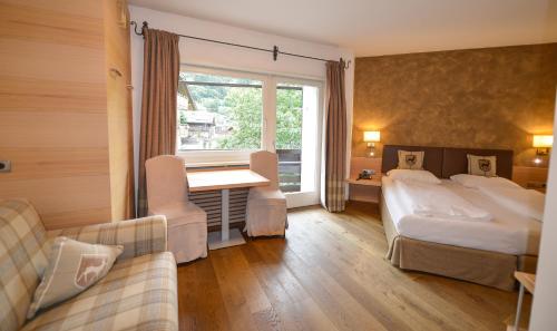 a hotel room with a bed and a desk at Residence Hotel Alpinum in Campo Tures
