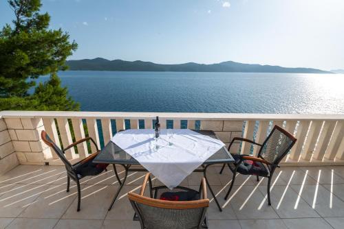 a table and chairs on a balcony with a view of the water at Beach Villa Ratac in Slano