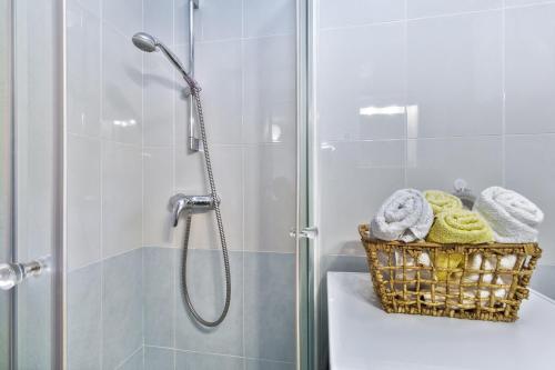 La salle de bains est pourvue d'une douche et d'un panier de serviettes. dans l'établissement Apartment Sunset Colours, à Umag