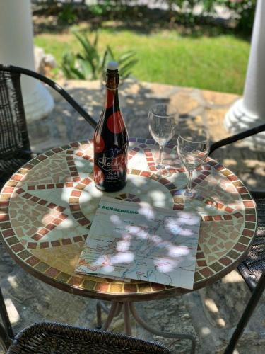 a glass table with a bottle and two glasses on it at Casa Rural Boas, con vistas impresionantes, Barbacoa en Cómpeta by CostaDelSolEscapes in Cómpeta