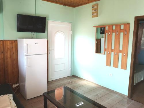 a kitchen with a white refrigerator and a window at Apartments Sandra in Lopar