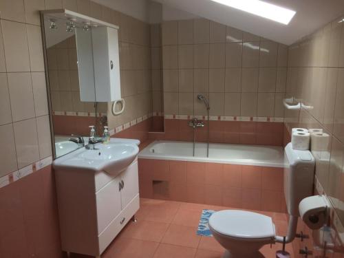 a bathroom with a sink and a toilet and a tub at House Ema in Barbat na Rabu