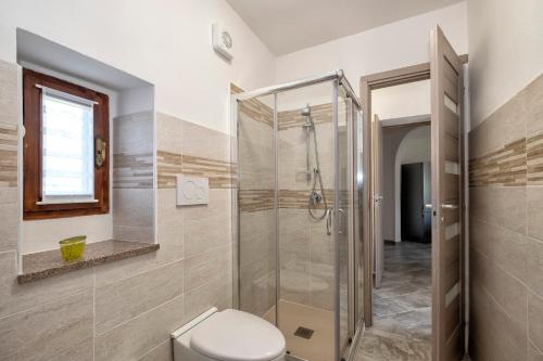 La salle de bains est pourvue d'une cabine de douche et de toilettes. dans l'établissement Casa delle rose, à Verbania