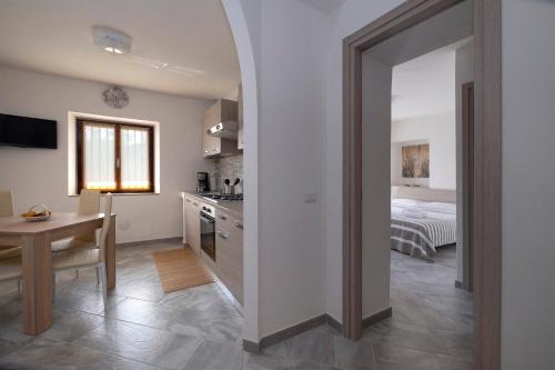 Il comprend une cuisine et une salle à manger avec une table et un lit. dans l'établissement Casa delle rose, à Verbania