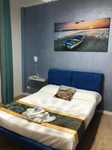 a bed with a blue headboard and a picture of a boat at A colazione da Tiffany in Pisa