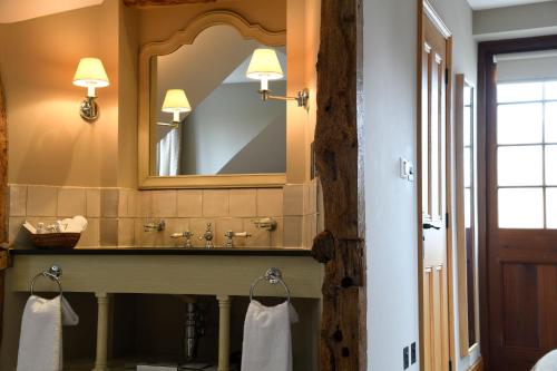 y baño con lavabo y espejo. en The Bell at Ramsbury, en Marlborough