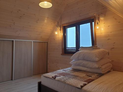 a bedroom with a bed with a stack of towels at Los Reyes II - klimatyzowane domki in Krynica Morska