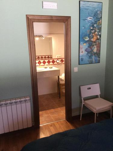 sypialnia z lustrem, umywalką i stołem w obiekcie El interior de Gaia w mieście Arriondas