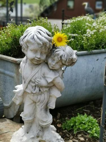 a statue of a child holding a flower in its mouth at Im Erzgebirge Wandern, Fahrrad fahren oder entspannen in Ehrenfriedersdorf