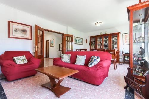 a living room with a red couch and a table at Charming Guesthouse - Sónias Houses in Lisbon