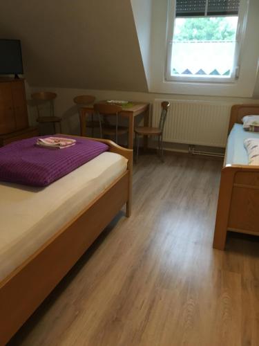 een slaapkamer met een bed en een tafel en stoelen bij Haus Ursula in Brake