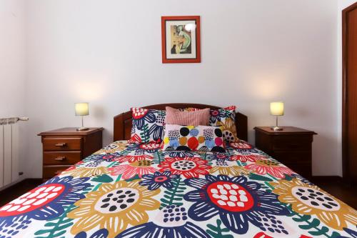 sypialnia z kolorowym łóżkiem z 2 stolikami nocnymi w obiekcie Charming Guesthouse - Sónias Houses w Lizbonie