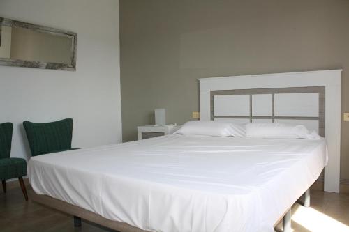 Les DevesesにあるMaite LOCDENIAのベッドルーム(大きな白いベッド1台、椅子2脚付)