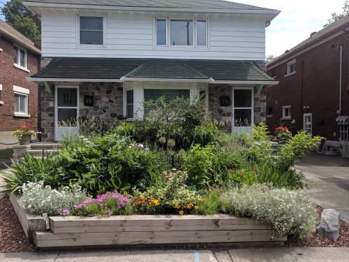 a garden in front of a house with flowers at Elcho's ExplOre Ottawa #3 in Ottawa
