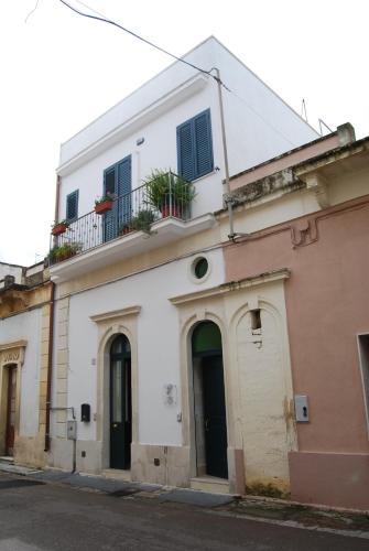 a white building with a balcony on top of it at Dafne B&B in Cutrofiano