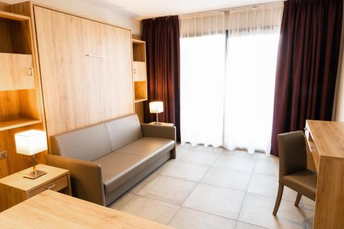a waiting room with a couch and a window at Hotel Residence Lido Marana Bastia Furiani in Furiani