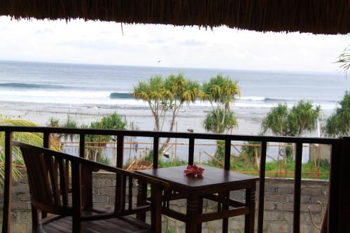 a table and chairs on a balcony with the beach at Twilight Ceningan in Nusa Lembongan