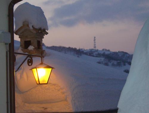 a light in a window with snow on it at Agriturismo Pozzuolo in Serrungarina