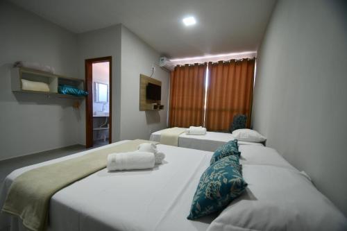 2 camas en una habitación de hotel con 2 camas sidx sidx sidx en Pousada Barra Sul en Laguna