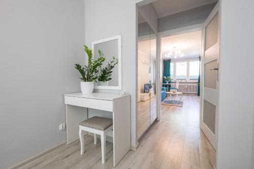 a living room with a white table and a mirror at Apartament uJasia in Słupsk
