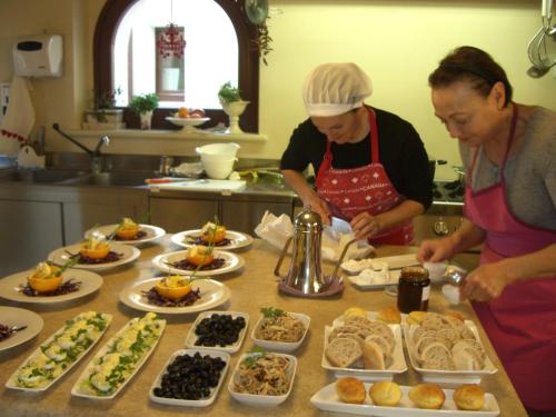 two women standing in a kitchen preparing food at Agriturismo Pozzuolo in Serrungarina