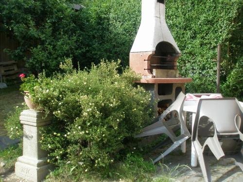a table and chairs and a fireplace in a garden at Pension Jana Tatrovice in Tatrovice
