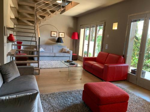a living room with a red couch and a staircase at Exclusive Loft 300mt by the sea Forte dei Marmi in Forte dei Marmi