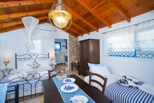 a living room with two beds and a table at Agyrovoli Bungalow in Skala Kallirachis