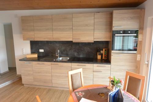 a kitchen with wooden cabinets and a table with a dining room at Haus Erli in Mittenwald